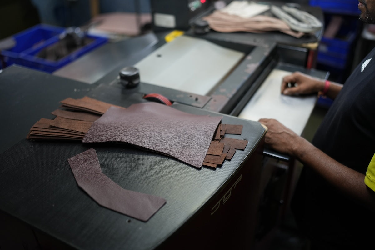 Leya artisan working with leather pieces